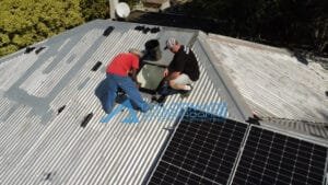 Aerial drone view of roof with TM Waterproofing director inspecting and technician covering glass surfaces for protection.
