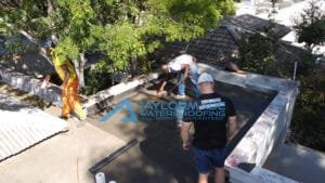 flat roof with TM Waterproofing installing torch‑on membrane.