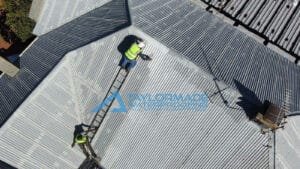 TM Waterproofing repairing and painting a corrugated roof section for long lasting protection.