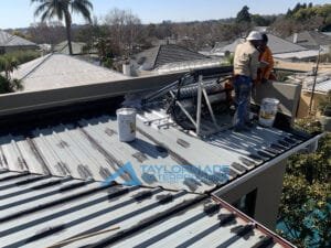 TM Waterproofing painting a corrugated roof in Parkhurst, applying protective coating for durability and water resistance.