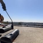 Close up view of TM Waterproofing using blow torch to install a torch‑on waterproofing membrane.