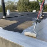 TM Waterproofing painting the flat roof surface at the Parktown North waterproofing project, ensuring even coverage and lasting protection.