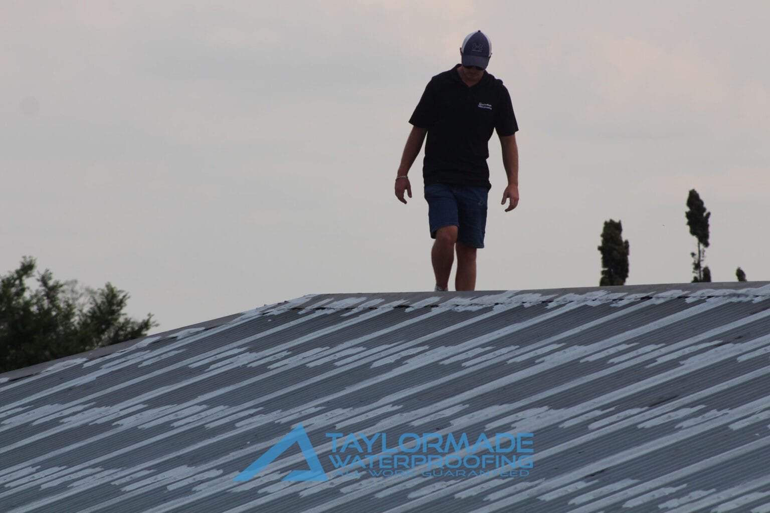 Corrugated roof under inspection and painting drying, showing ongoing quality control and roof protection.