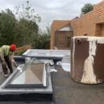 Early stage of protective painting on a roof, after torch-on membranes application.