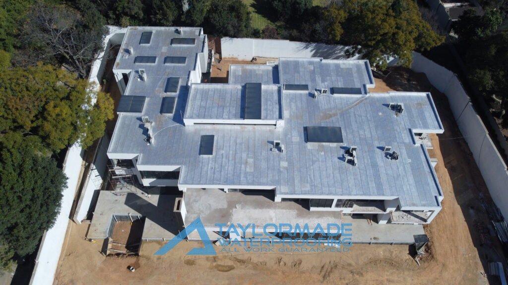 Drone aerial view of a luxury Sandton home showing waterproofing work on roof slabs, balconies, and wall tanking.