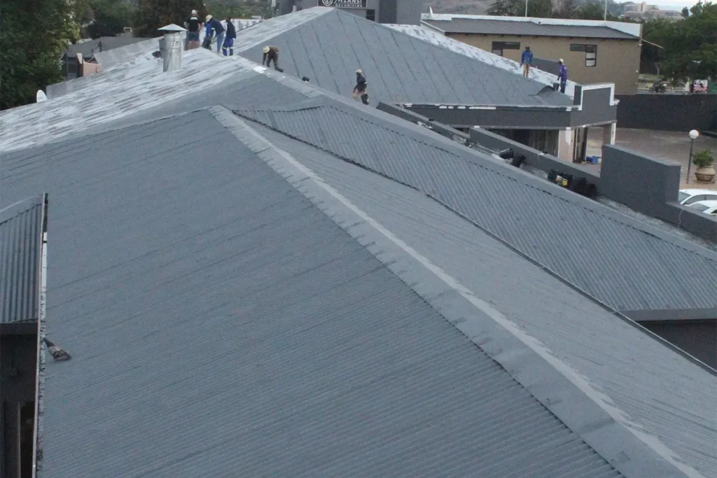 Ground-level image of acrylic roof waterproofing Roodepoort showing the main roof with final waterproof coating applied