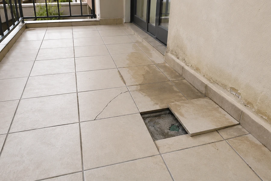 Balcony leak repair Johannesburg image showing worn balcony tiles, water staining and wall damage near the tiled surface