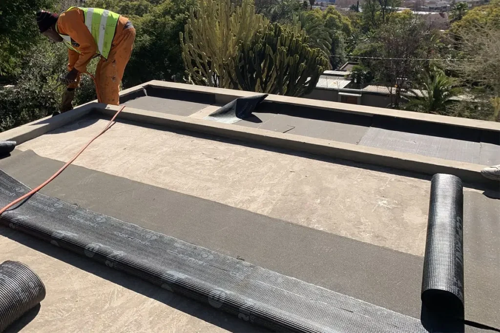 Flat roof waterproofing Westcliff rubber membrane rolled out across the roof surface