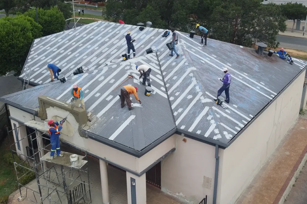 Image of team completing metal roof waterproofing Roodepoort on the separate building roof