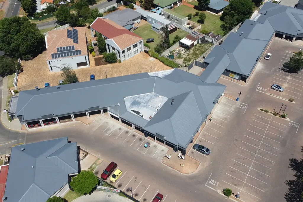 Angled drone image of retail centre waterproofing Roodepoort showing completed grey waterproof roof coating