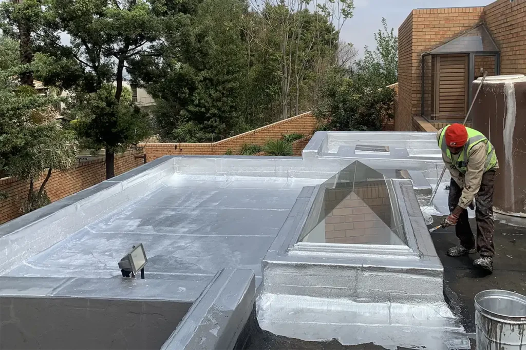 Roof Waterproofing Bedfordview UV coating being applied beside skylight after torch-on