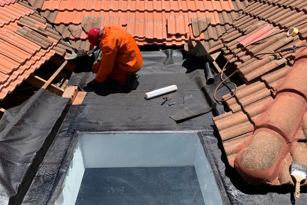 Torch-on waterproofing Linden being applied around skylight flat roof area