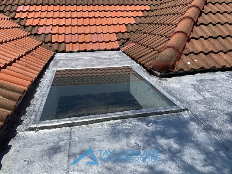 Re‑tiled pitched roof adjoining a flat section finished with torch‑on waterproofing membrane.