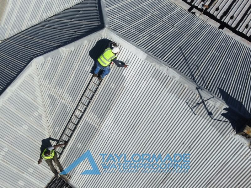 TM Waterproofing repairing and painting a corrugated roof section for long lasting protection.