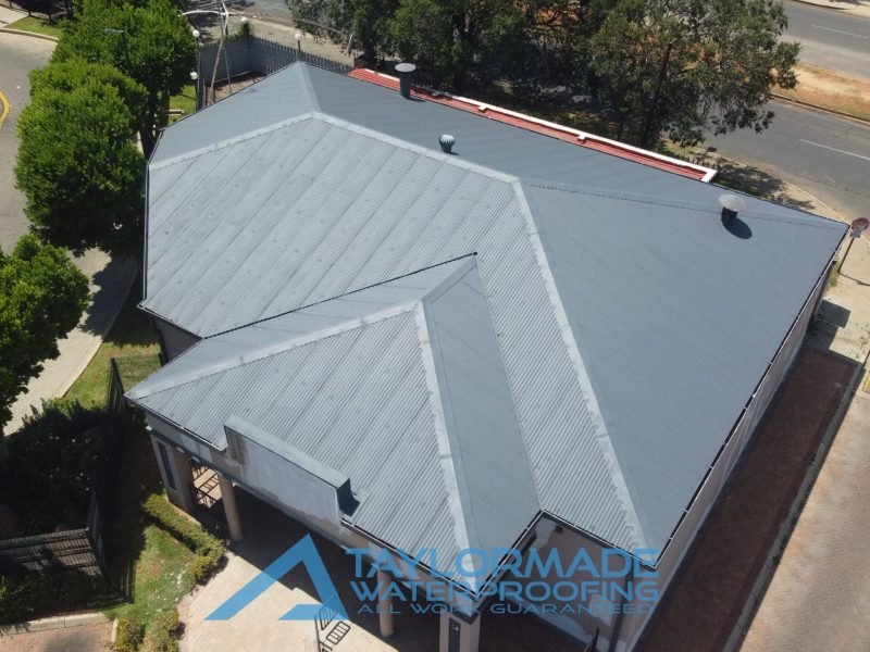 Drone top view of corrugated roof with paint applied.