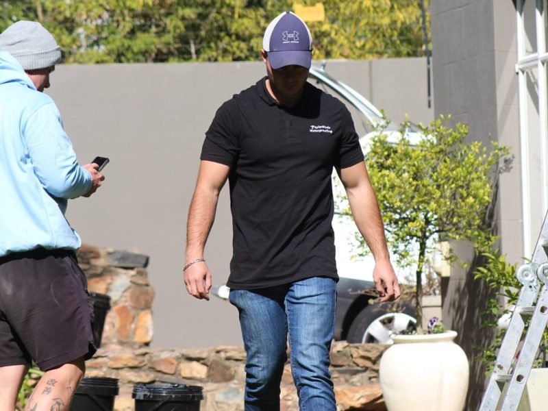 TM Waterproofing experts preparing materials for acrylic waterproofing application on a roof