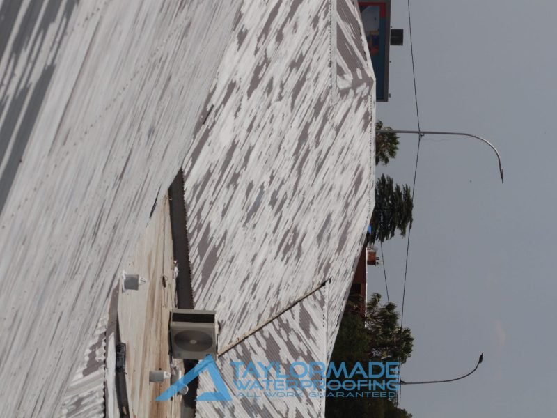 Wide view of corrugated metal roof from opposite angle, showing even application of Membranes protective coating.