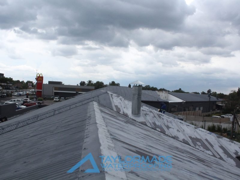 Corrugated roof with paint drying in progress, showing ongoing roofing work and coverage.