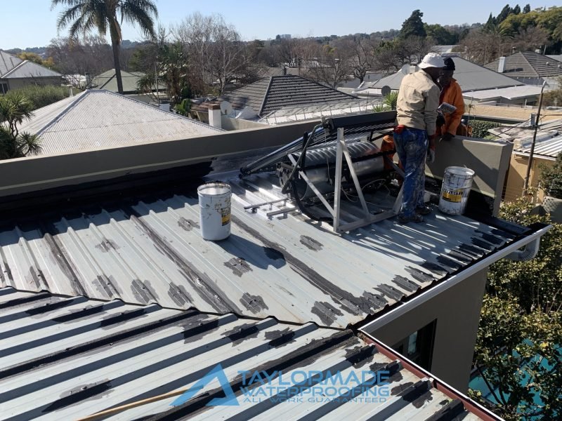 TM Waterproofing painting a corrugated roof in Parkhurst, applying protective coating for durability and water resistance.