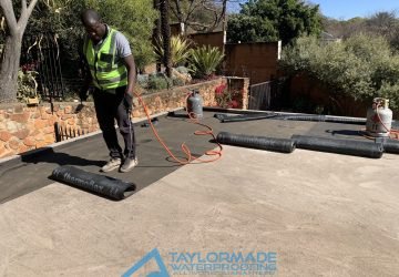 TM Waterproofing applying a torch‑on waterproofing membrane with a blow torch.
