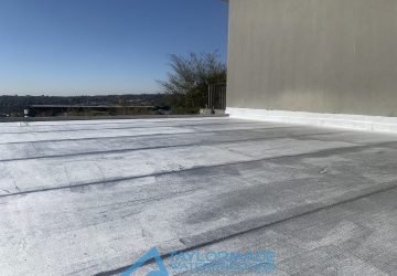 Flat roof, showing a uniform, sealed surface with protective coating.
