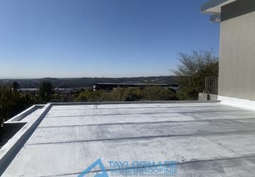 Flat roof showing a uniform, sealed surface with protective coating.