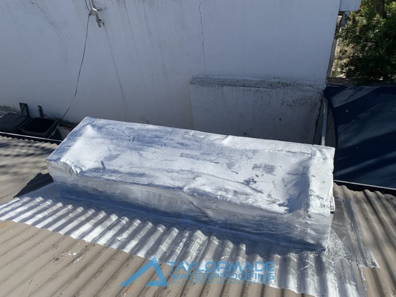Flat roof waterproofed with membranes and painted in silver paint for UV and water protection.