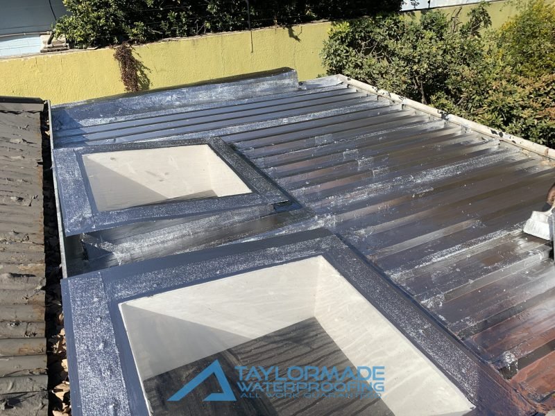 Renovated Parkhurst roof with board and silver protective coating applied, demonstrating board & torch and torch-on waterproofing protection.