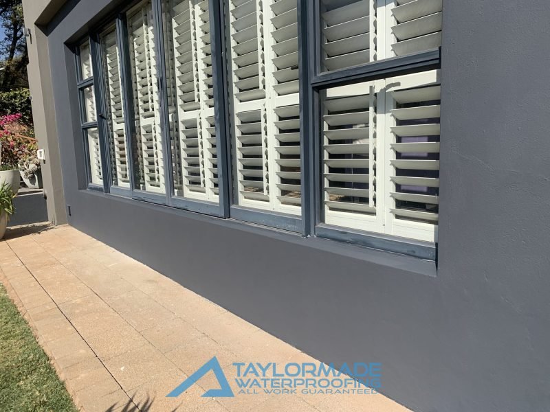 Side view of the back wall after professional painting and torch-on waterproofing treatment.