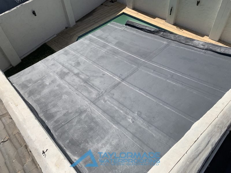 Flat roof with torch-on membrane fully applied, highlighting completed board & torch waterproofing work by TM Waterproofing.
