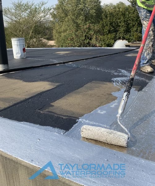 TM Waterproofing painting the flat roof surface at the Parktown North waterproofing project, ensuring even coverage and lasting protection.