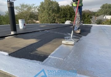 TM Waterproofing technician painting the flat roof surface at the Parktown North waterproofing project, ensuring even coverage and lasting protection.