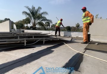TM Waterproofing painting the edge and roof surface of the Bryanston roof slab with protective paint for durability and weather resistance.