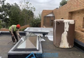 Early stage of protective painting on a roof, after torch-on membranes application.