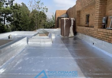 Flat roof with silver paint & torch-on membranes application completed, demonstrating full board & torch waterproofing coverage.
