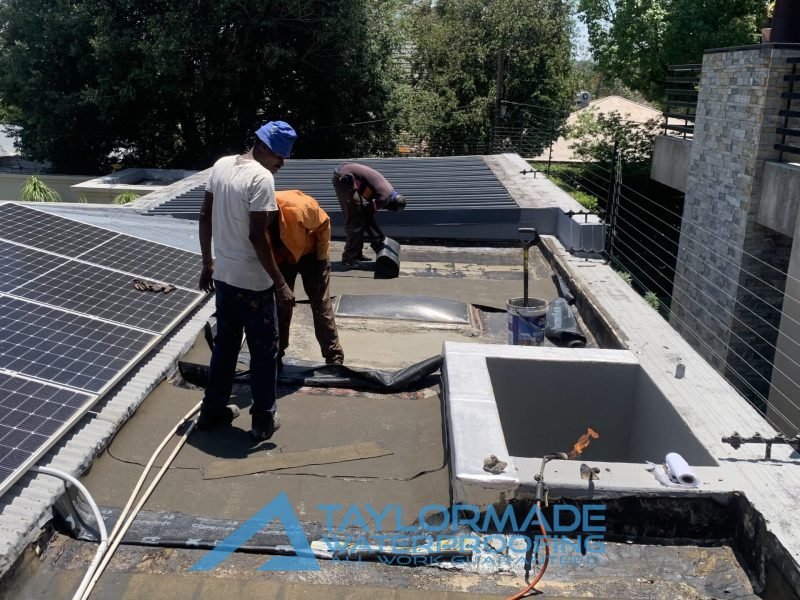 TM Waterproofing installing membranes on a flat slab roof, preparing for torch waterproofing (torch-on system) around the skylight area in Parkhurst.