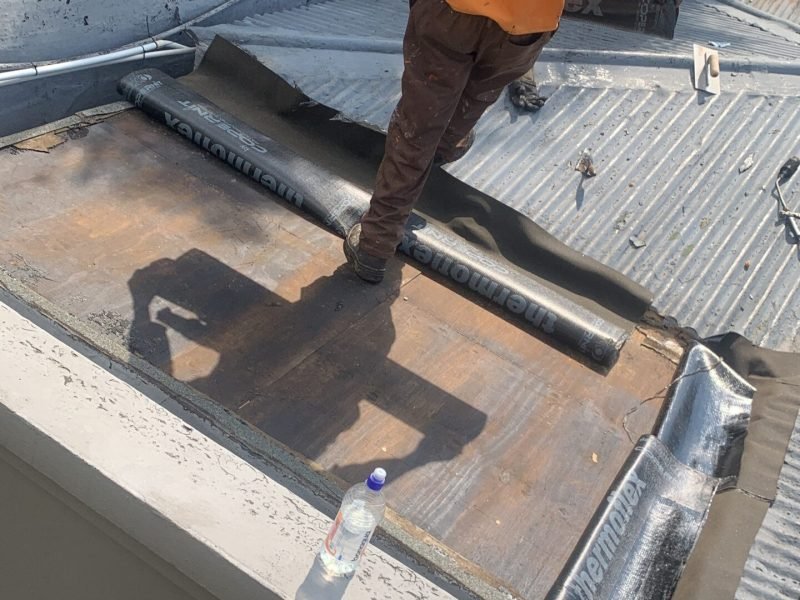 Preparing a flat roof area for membranes & torch waterproofing at a Parkhurst slab and skylight project.