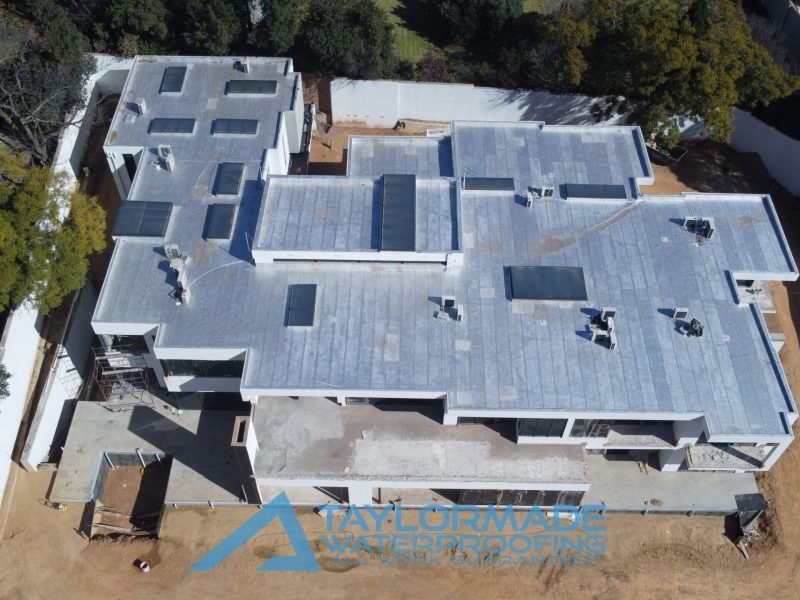 Drone aerial view of a luxury Sandton home showing waterproofing work on roof slabs, balconies, and wall tanking.