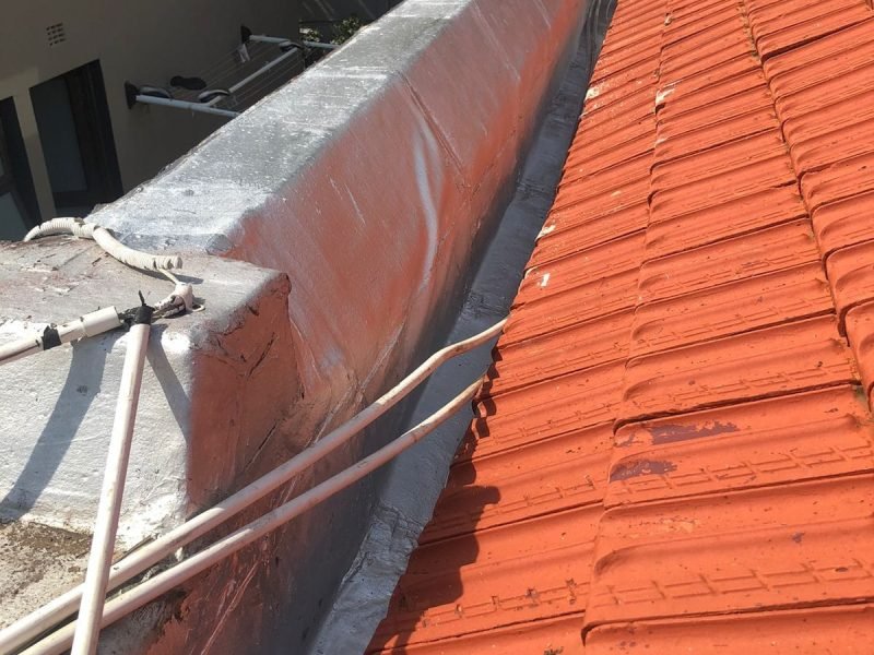 Rooftop wall fully treated with torch-on waterproofing membrane and paint finish.
